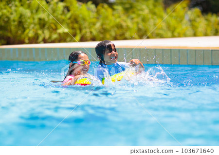 Child in swimming pool on toy ring. Kids swim. 103671640