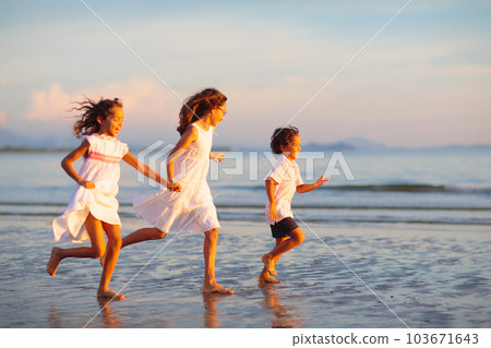 Child playing on ocean beach. Kid at sunset sea. 103671643