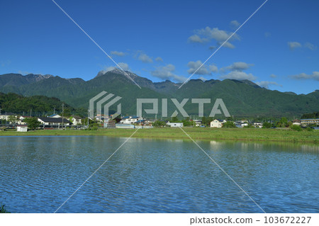 Wind ripples across the surface of the paddy fields waiting for rice planting in Hakushu-cho, Hokuto City 103672227