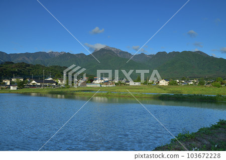 Wind ripples across the surface of the paddy fields waiting for rice planting in Hakushu-cho, Hokuto City 103672228