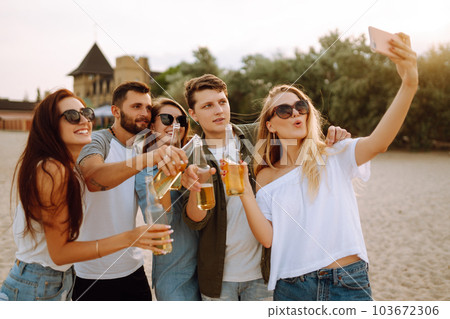 Group of people doing selfie with phone at the beach. Young friends enjoy summer party together. 103672306