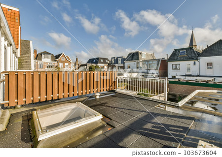 a rooftop with some buildings in the background and a blue sky above it that looks like an overcasting place 103673604