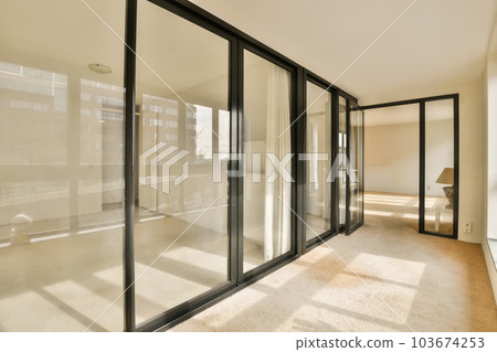 an empty room with sliding glass doors and floor to ceiling windows in a new apartment building, london, uk stock photo an empty room with sliding glass doors and floor to ceiling windows in a new apartment building, london, uk stock photo 103674253