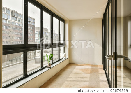 an empty room with large windows and plants in the window sid on the right hand side of the room an empty room with large windows and plants in the window sid on the right hand side of the room 103674269