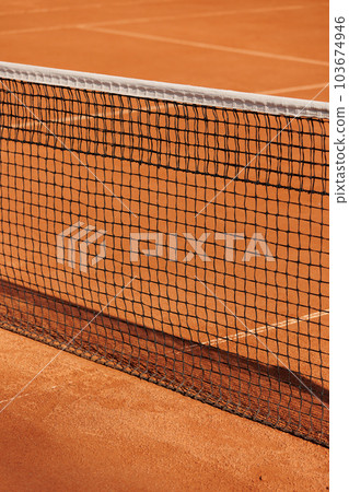 tennis net court made of red clay soil with markings for game or competition. sports and recreation tennis net court made of red clay soil with markings for game or competition. sports and recreation 103674946