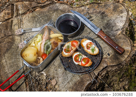 Cooking food using a bonfire at the campsit 103676288