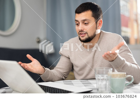Smiling young man making video call on laptop at home Smiling young man making video call on laptop at home 103676824