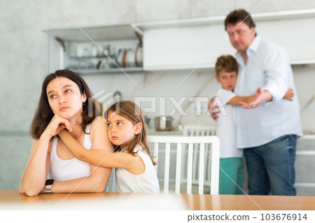 Family with two children in kitchen during quarrel 103676914