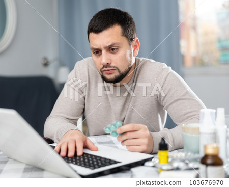 Young man looking for information about medicines on laptop Young man looking for information about medicines on laptop 103676970