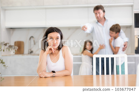 Offended mother sitting at the kitchen table Offended mother sitting at the kitchen table 103677047