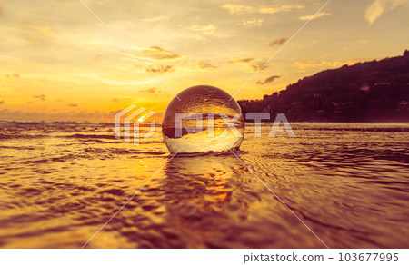 Magnificent sky above the crystal ball on the beach..The beautiful reflection of the sky above the crystal ball on the wet sand beach..Unique and creative travel and nature idea 103677995