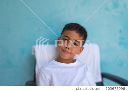 A cute boy with a smiling face healthy and cheerful..The cute boy wearing a white tee shirt spoke and made many expressions of emotions..Studio portrait, health concept with blue background. . A cute boy with a smiling face healthy and cheerful..The cute boy wearing a white tee shirt spoke and made many expressions of emotions..Studio portrait, health concept with blue background. . 103677996