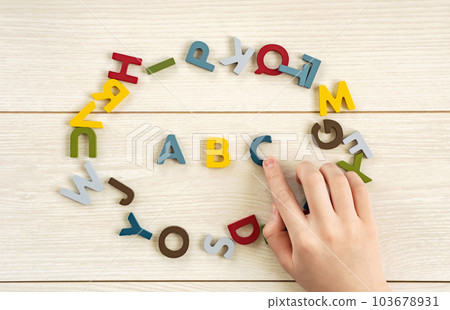 女孩的手指向字母表。英語、教育、兒童學習、英語會話等。 女孩的手指向字母表。英語、教育、兒童學習、英語會話等。 103678931