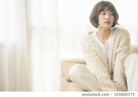 Young woman relaxing on the sofa (black mist filter) 103680575