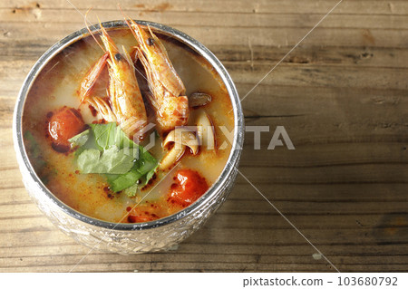 A bird's-eye view of steaming tom yum goong with tomato, coriander and shrimp 103680792