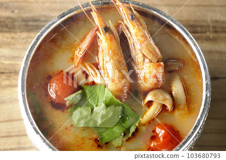 A bird's-eye view of steaming tom yum goong with tomato, coriander and shrimp 103680793