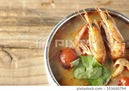 A bird's-eye view of steaming tom yum goong with tomato, coriander and shrimp 103680794