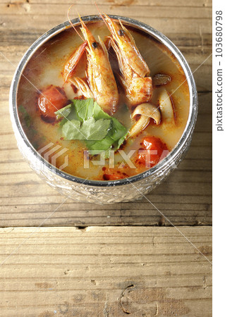 A bird's-eye view of steaming tom yum goong with tomato, coriander and shrimp 103680798