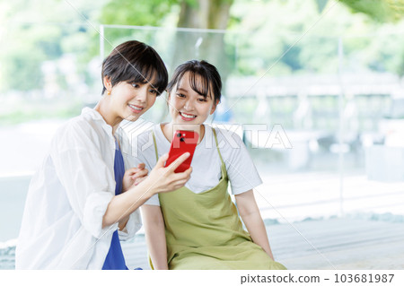 女子旅行中，一位女士在足浴中看著智能手機 103681987