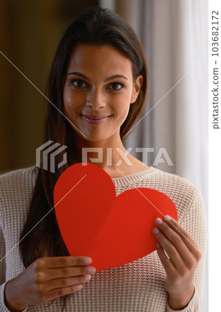 Woman, face and red heart paper in house or home for valentines day, cardiology surgery organ donor or support. Portrait, smile or happy Indian person with love cut out for trust, comfort or kindness Woman, face and red heart paper in house or home for valentines day, cardiology surgery organ donor or support. Portrait, smile or happy Indian person with love cut out for trust, comfort or kindness 103682172