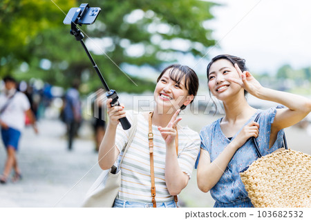 A woman taking a commemorative photo on a girls' trip A woman taking a commemorative photo on a girls' trip 103682532