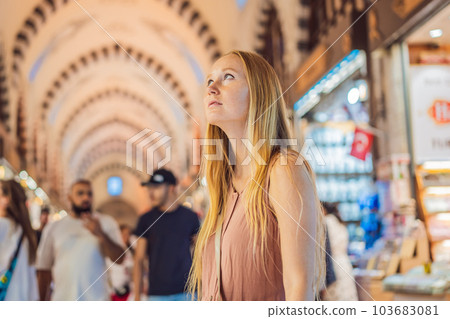 A tourist woman walks among the countless shops at the Grand Bazaar and Egyptian Bazaar in Istanbul. Shopping and travel in Turkey concept. Istanbul historical Egyptian Bazaar. Misir Carsisi, spice A tourist woman walks among the countless shops at the Grand Bazaar and Egyptian Bazaar in Istanbul. Shopping and travel in Turkey concept. Istanbul historical Egyptian Bazaar. Misir Carsisi, spice 103683081