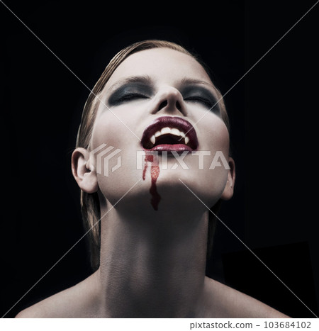 Blood, woman and vampire with fantasy, fangs and lady against a dark studio background. Female person, supernatural being and girl mystic, aesthetic and monster with creativity, demon and character Blood, woman and vampire with fantasy, fangs and lady against a dark studio background. Female person, supernatural being and girl mystic, aesthetic and monster with creativity, demon and character 103684102