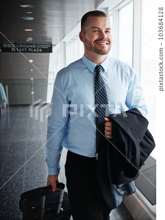 This business trip is going great so far. an executive businessman walking through an airport during a business trip. 103684128