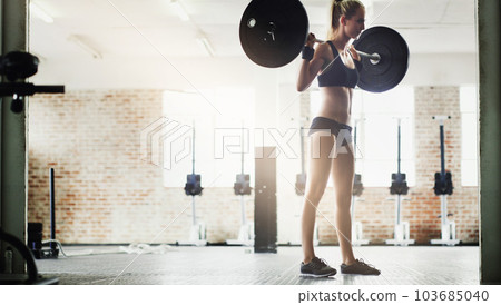 Fitness, training or woman lifting a barbell in gym studio for biceps growth or healthy strength development. Sports athlete, focused girl or bodybuilder with strong arms in exercise or body workout Fitness, training or woman lifting a barbell in gym studio for biceps growth or healthy strength development. Sports athlete, focused girl or bodybuilder with strong arms in exercise or body workout 103685040