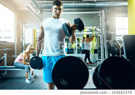 Dont let anyone take away your determination. a young man working out alone in the gym. 103685379