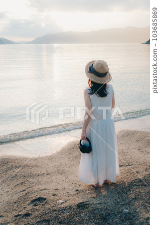Woman wearing headphones looking at the sea 103685869