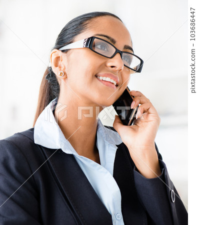 chasing down all the opportunities. Shot of a young businesswoman making a call using her smartphone. 103686447
