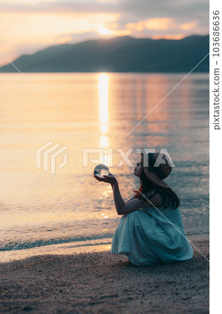 A woman standing on the beach 103686636