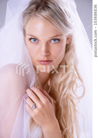 Portrait, beautiful bride and a wedding dress or woman in a lace veil and newlywed with diamond ring on finger. Face, bridal gown, makeup and hairstyle or jewellery for marriage and celebration Portrait, beautiful bride and a wedding dress or woman in a lace veil and newlywed with diamond ring on finger. Face, bridal gown, makeup and hairstyle or jewellery for marriage and celebration 103686836
