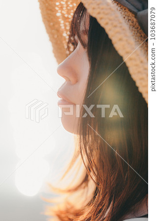 A woman standing at sunset A woman standing at sunset 103687079