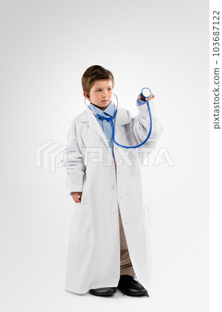 I want to help people when Im big. Studio shot of an adorable little boy dressing up as a doctor. 103687122