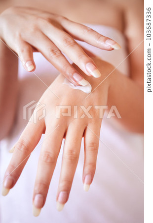 Beautiful hands are underrated. Shot of an unrecognizable woman applying moisturiser to her hand at home. 103687336
