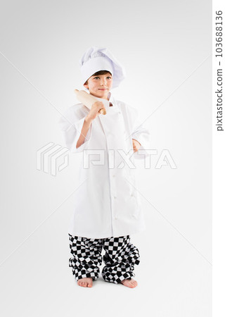 Oh boy, I cant wait to be a baker. Studio shot of an adorable little boy dressing up as a chef. 103688136