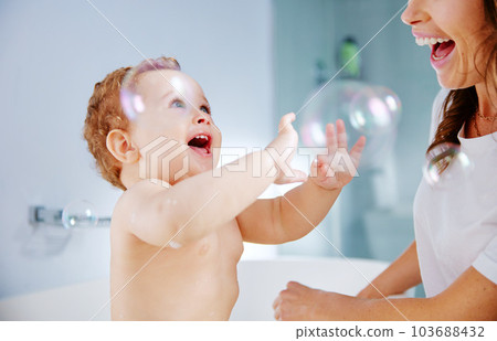 Bubbles are always fun. Shot of a mother bathing her baby at home. 103688432