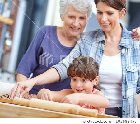 Shes doing it perfectly. a three generational family baking together. 103688453