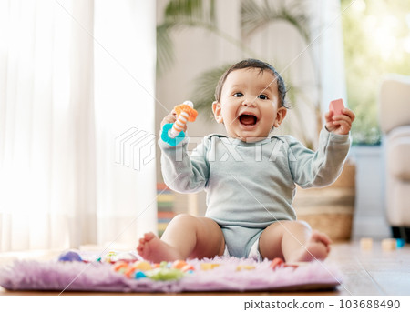 Portrait, smile and happy baby with toys on floor for fun, playing and game at home. Face, excited and toddler boy with creative building blocks for child development, learning or play in living room Portrait, smile and happy baby with toys on floor for fun, playing and game at home. Face, excited and toddler boy with creative building blocks for child development, learning or play in living room 103688490