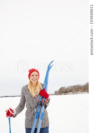 The perfect day for a ski adventure. Three quarter length shot of a beautiful young woman holding ski equipment. 103688651