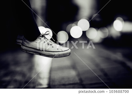 Closeup, monochrome and sneakers outdoor, city and lights with creativity, road and artistic. Zoom, person or model with shoes, street and grey with footwear, night or creative with fashion or travel Closeup, monochrome and sneakers outdoor, city and lights with creativity, road and artistic. Zoom, person or model with shoes, street and grey with footwear, night or creative with fashion or travel 103688700