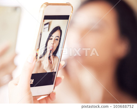 This mirror works for me. Shot of a beautiful young woman using her phone as a mirror while applying lipstick at home. This mirror works for me. Shot of a beautiful young woman using her phone as a mirror while applying lipstick at home. 103688752