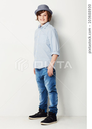 Cool, stylish and portrait of a child in fashion isolated on a white background in a studio. Happy, fashionable and a young boy model in jeans and clothes for style, happiness and confidence 103688930