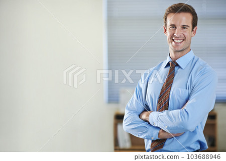 Climbing the corporate ladder. A young businessman standing and smiling with his arms folded - copyspace. 103688946