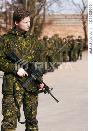 Army, military and soldier with a gun on a battlefield ready for war, fight or mission with courage and loyalty to a country. Hero, outdoor and man professional in service holding a rifle in gear 103688966
