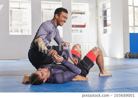 People laugh together in gym, martial arts and fitness with combat, jiu jitsu and students learning self defense skills. Fight, exercise and MMA with fighting sport and men with fun and train at dojo People laugh together in gym, martial arts and fitness with combat, jiu jitsu and students learning self defense skills. Fight, exercise and MMA with fighting sport and men with fun and train at dojo 103689001