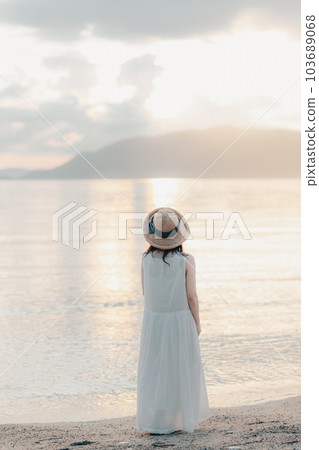 A woman standing on the coast A woman standing on the coast 103689068