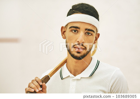 The coolest cat at the squash court. a confident young man standing on a squash court. 103689305